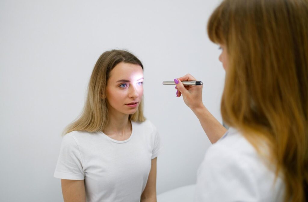 An eye doctor shining a light in a patient's eye.