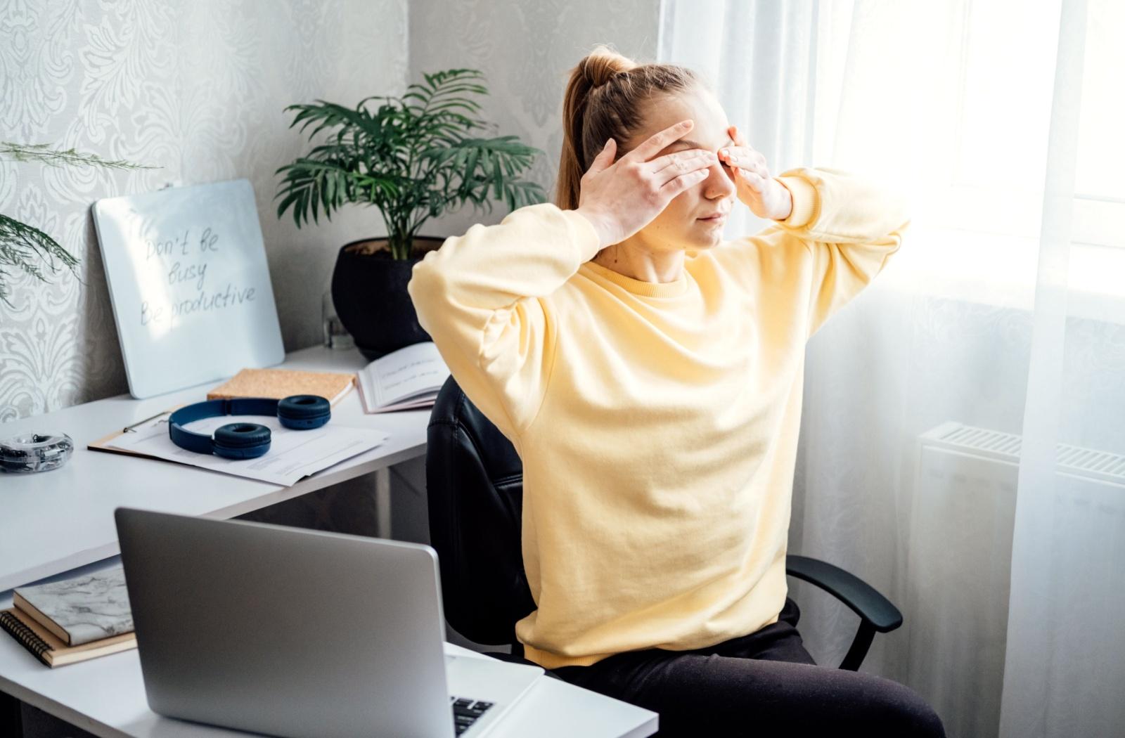 A person holding their eyes, experiencing eye pressure.